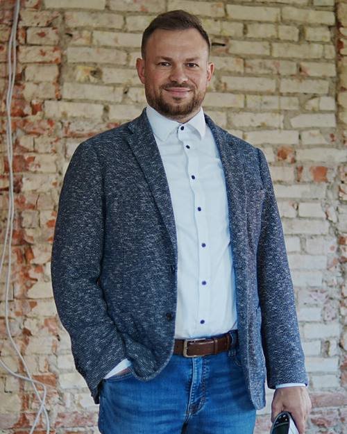 Falco Witschel, Energieberater und Sachverständiger, vor einer freigelegten Ziegelwand